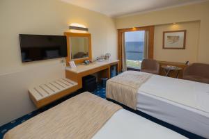 
a hotel room with two beds and a television at Best Western Plus Hotel Konak in İzmir
