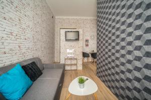 a living room with a couch and a brick wall at Susan Apartment near Blaha Lujza Square in Budapest