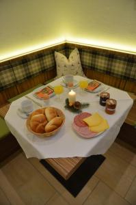 una mesa con pan, bebidas y velas. en Apartmenthaus Bader, en Leutasch