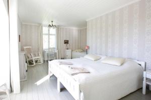 a white bedroom with two beds and a table at Tammiston Bed&Breakfast in Naantali