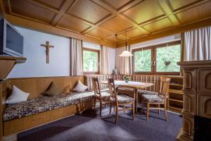 um quarto com um banco com uma mesa e uma cruz na parede em Haus Sageler em Tux