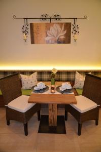 - une table à manger avec 2 chaises et un canapé dans l'établissement Apartmenthaus Bader, à Leutasch