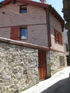 une maison en pierre avec une porte en bois et un mur en pierre dans l'établissement La Salamandra, à El Arenal