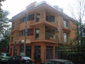 a large orange building with balconies on a street at Hotel Milenium in Sofia