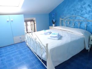a bedroom with a white bed with blue walls at B&B Alòs in Sapri