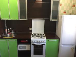 アンガルスクにあるАпартаменты LUX в центреのキッチン(緑のキャビネット、コンロ、冷蔵庫付)