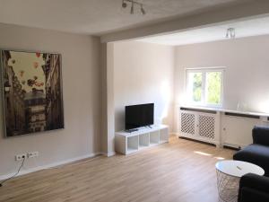 an empty living room with a tv and a couch at Apartments Thommen Lohengrinstr in Nuremberg