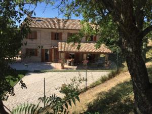 a house with a fence in front of it at B&B Profumo delle Marche in Montefano
