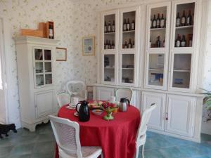 a dining room with a red table and white chairs at Chateau Rousselle in Saint-Ciers-de-Canesse