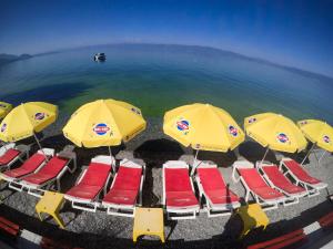 eine Luftansicht von Liegen und Sonnenschirmen am Strand in der Unterkunft Hotel Dva Bisera in Ohrid