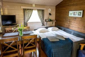 a bedroom with a bed and a desk and a table at Santalahti Resort Cottages & Villas in Kotka