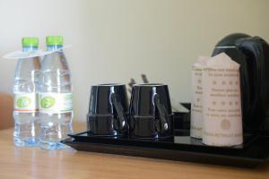 a bottle of water and a cup of coffee on a table at Ocean Retreat and Spa in Guraidhoo