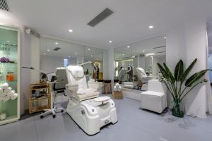 a salon with a white chair and a mirror at Mykonos Blanc - Preferred Hotels & Resorts in Ornos