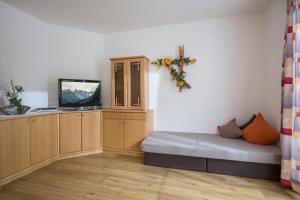 Cette petite chambre comprend un lit et une télévision. dans l'établissement Ferienhaus Regina, à Tux