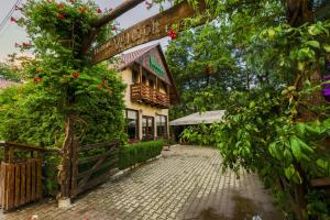 a building with flowers on the side of it at Pensiunea Restaurant Vándor in Cîmpu Cetăţii