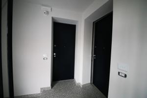 een hal met twee zwarte deuren in een kamer bij Green House 71 in Verona