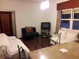 Habitación con cama, silla y TV. en Departamento muy amplio en excelente ubicación en Mendoza