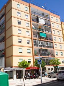 een hoog gebouw op een straat met auto's geparkeerd voor het bij Infanta Beatriz in Sanlúcar de Barrameda