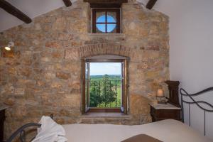 a bedroom with a stone wall with a window at Nona Nina in Vižinada
