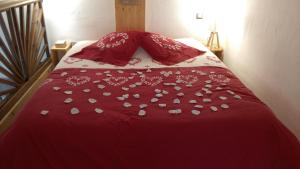 - un lit rouge avec une couette et des oreillers rouges dans l'établissement Spa Cabanon de Charme - Le Garagaï, à Meyreuil