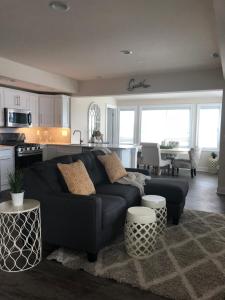 a living room with a black couch and a kitchen at Ocean Manor 1100 Inn in Ocean City