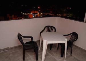 een witte tafel en 2 stoelen op een balkon bij Recanto Duas Peras in Caraguatatuba +2 foto's