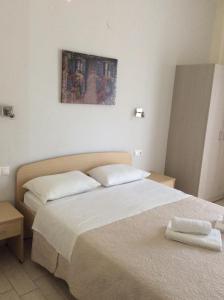 a bedroom with two beds and a painting on the wall at Elena Rooms in Plakias