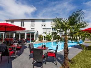 a restaurant with tables and chairs next to a pool at Hotel Andante Rust in Rust