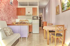 フエンヒロラにあるAurinko 6 Acogedor apartamento en Fuengirolaのキッチン、リビングルーム(ソファ、テーブル付)