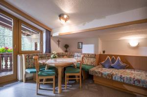- une salle à manger avec une table et un canapé dans l'établissement Ferienhaus Regina, à Tux
