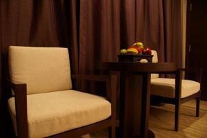 a room with two chairs and a table with a bowl of fruit at Panya Resort Hotel in Udon Thani