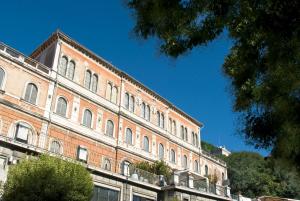 um grande edifício de tijolos com um céu azul ao fundo em Hotel Iris em Perugia