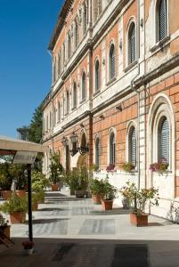 um grande edifício de tijolos com vasos de plantas em frente em Hotel Iris em Perugia