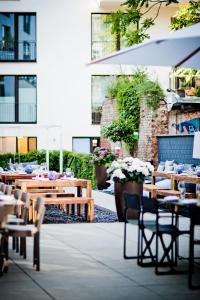 een patio met tafels en stoelen en een gebouw bij Hotel AMANO Rooms & Apartments in Berlijn