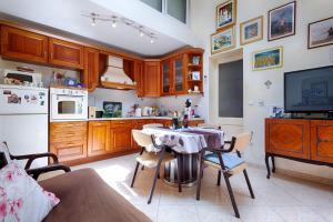 a kitchen with a table with chairs and a television at Apartments Kastelani in Komiža