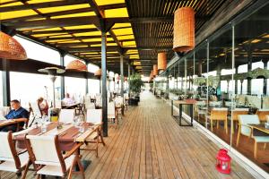 a restaurant with tables and chairs and people sitting at tables at Kaliakria Sea View Apartments in Topola