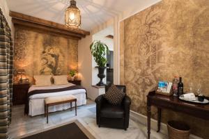 a bedroom with a bed and a chair at The Town House - Adults Only in Marbella