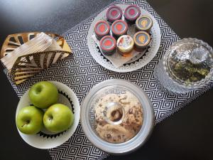 a table topped with plates of food and bowls of apples at Gate 25 in Blotzheim