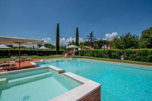 una piscina en un patio con sombrilla en Agriturismo Podere La Rocca, en Abbadia di Montepulciano