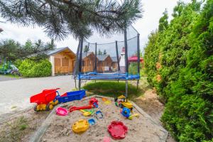 un parque infantil con juguetes en la arena y un columpio en Onyx, en Mielno