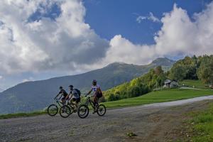 three people riding bikes down a dirt road at B&B Notte Stellata in Gaiola