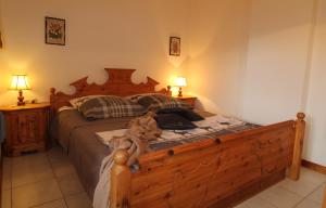 1 cama grande de madera en un dormitorio con 2 lámparas en Haus Franz by ISA AGENTUR, en Bad Kleinkirchheim