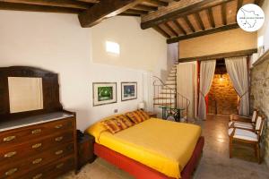 1 dormitorio con 1 cama, vestidor y silla en Casa Scuderia en Volterra