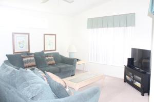 a living room with a couch and a tv at Water Oak IR700 in Orlando