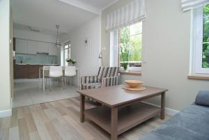 a living room with a table and a kitchen at Apartament Plaza in Rowy +4 photos