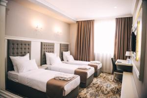Łóżko lub łóżka w pokoju w obiekcie Emerald Suite Hotel