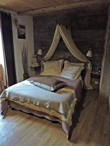 a bedroom with a large bed with a canopy at A la Bouge'Hôtes in Bellentre