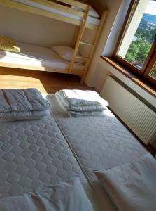 a bedroom with a bed and a window and a ladder at Apartman pod Kalváriou - rodinný dom in Banská Štiavnica