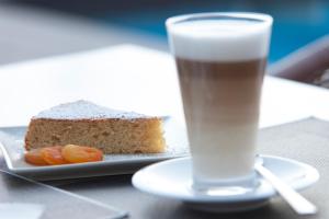 a plate with a piece of cake and a glass of milk at Es Corte Vell - Adults Only in Bunyola