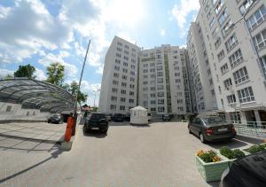 een parkeerplaats met auto's geparkeerd voor hoge gebouwen bij Apartment OneClickRent_05 - Smart House in Chişinău